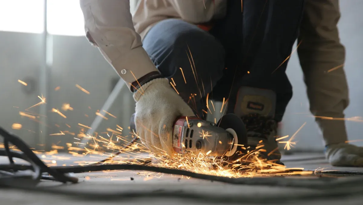 A worker is cutting sheet metal for fabrication.